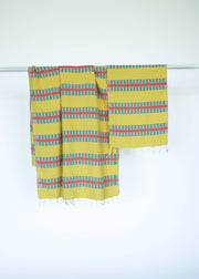 Yellow Turkish towel with colorful stripes on a white background